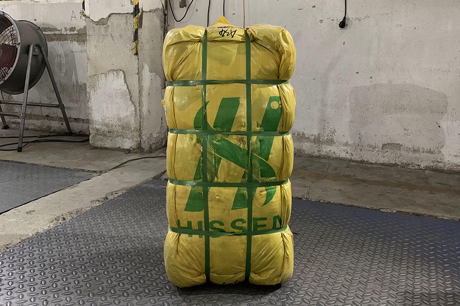 used shoes packed in a yellow bale with the Hissen logo